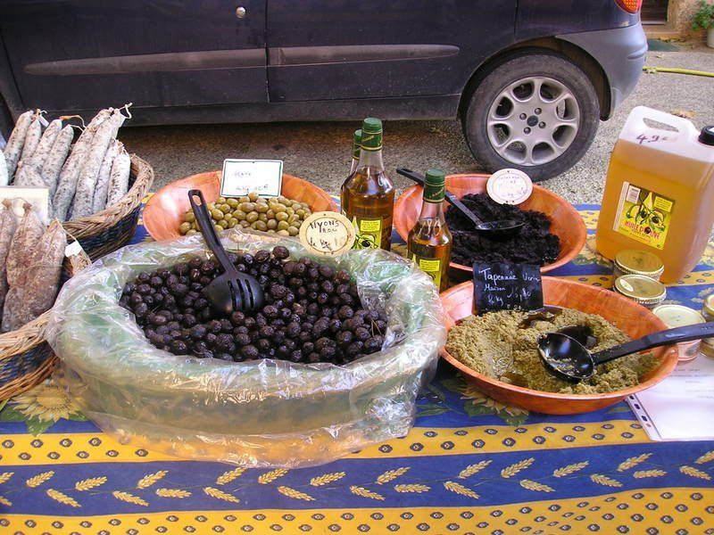 A table with bowls of olives and bottles of olive oil