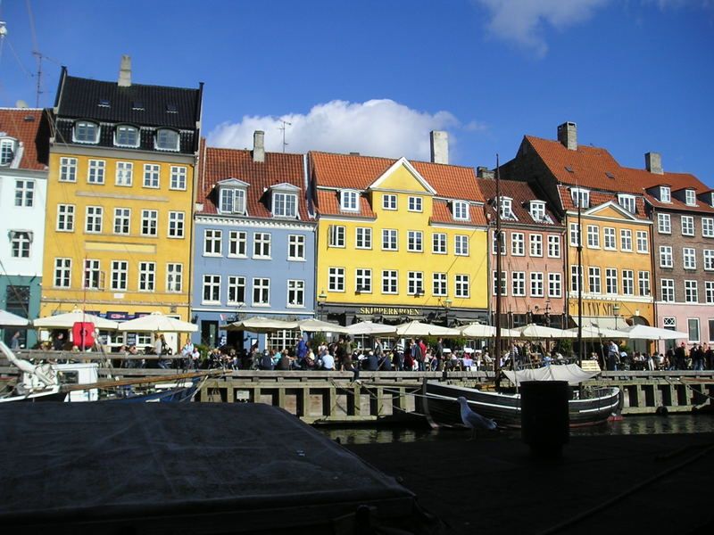 A row of buildings with umbrellas and a blue sky in the background