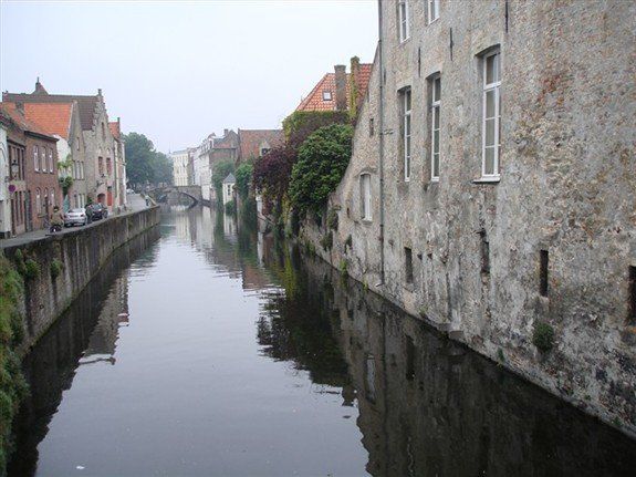 A river runs through a city between two buildings.
