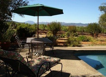 A pool with a table and chairs under an umbrella