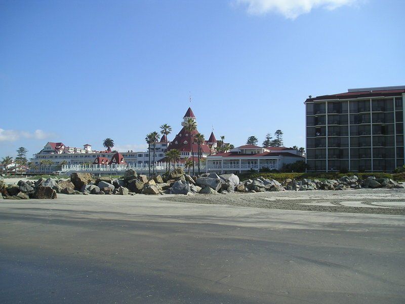 A large building with a red roof is on the beach