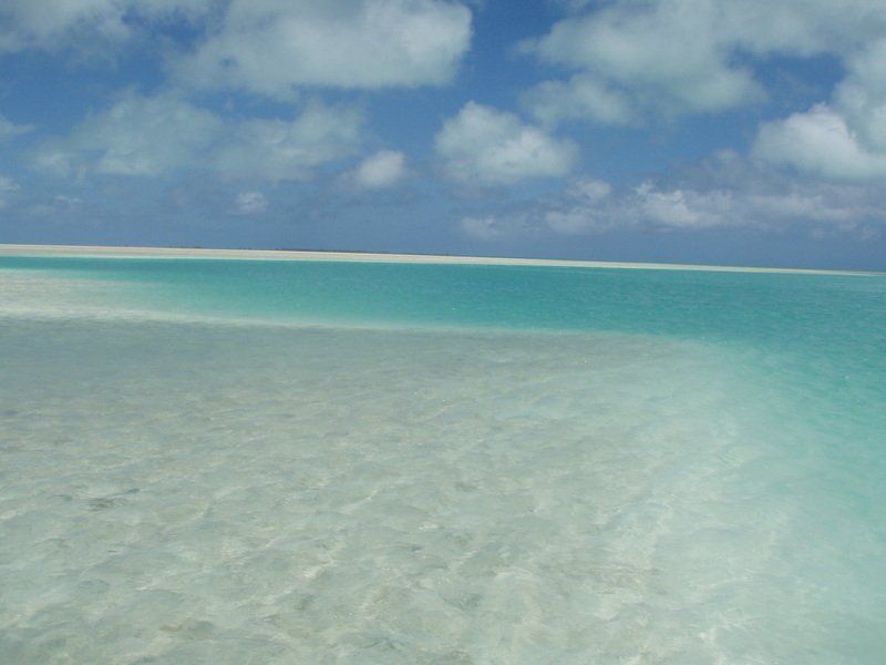 A sandy beach with turquoise water and a blue sky