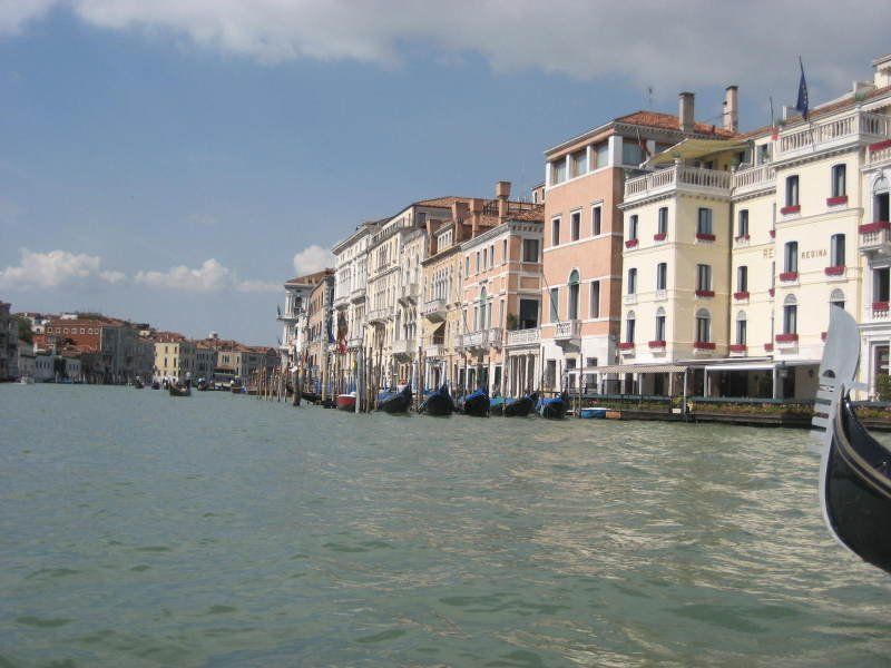 A row of buildings along a body of water with a boat in the foreground