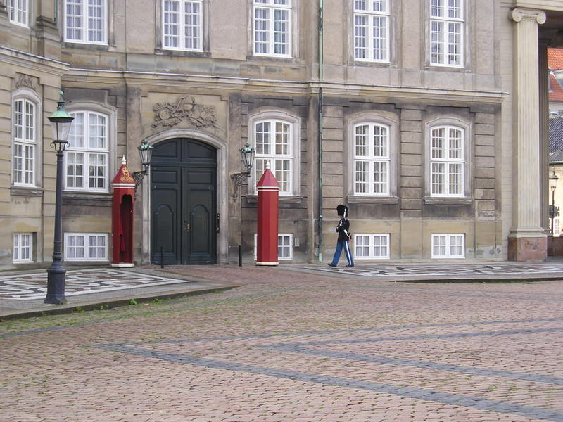 A man walking in front of a large building