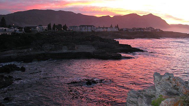A sunset over a body of water with mountains in the background