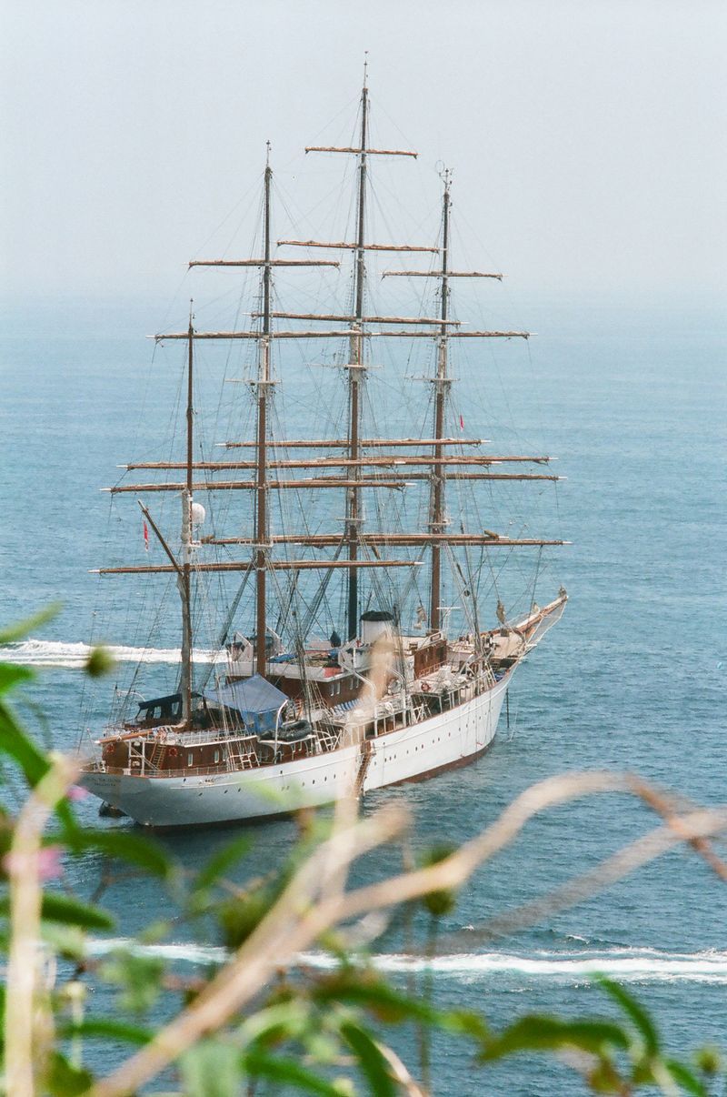A large sailboat is floating on top of a body of water.