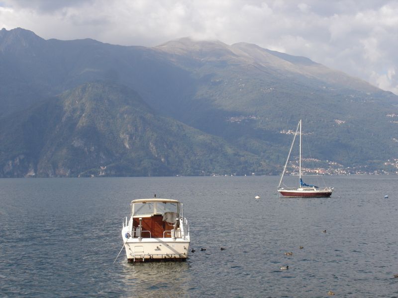 Two boats are in the water with mountains in the background