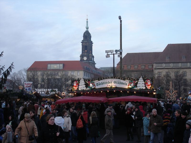 A crowd of people are gathered around a christmas market