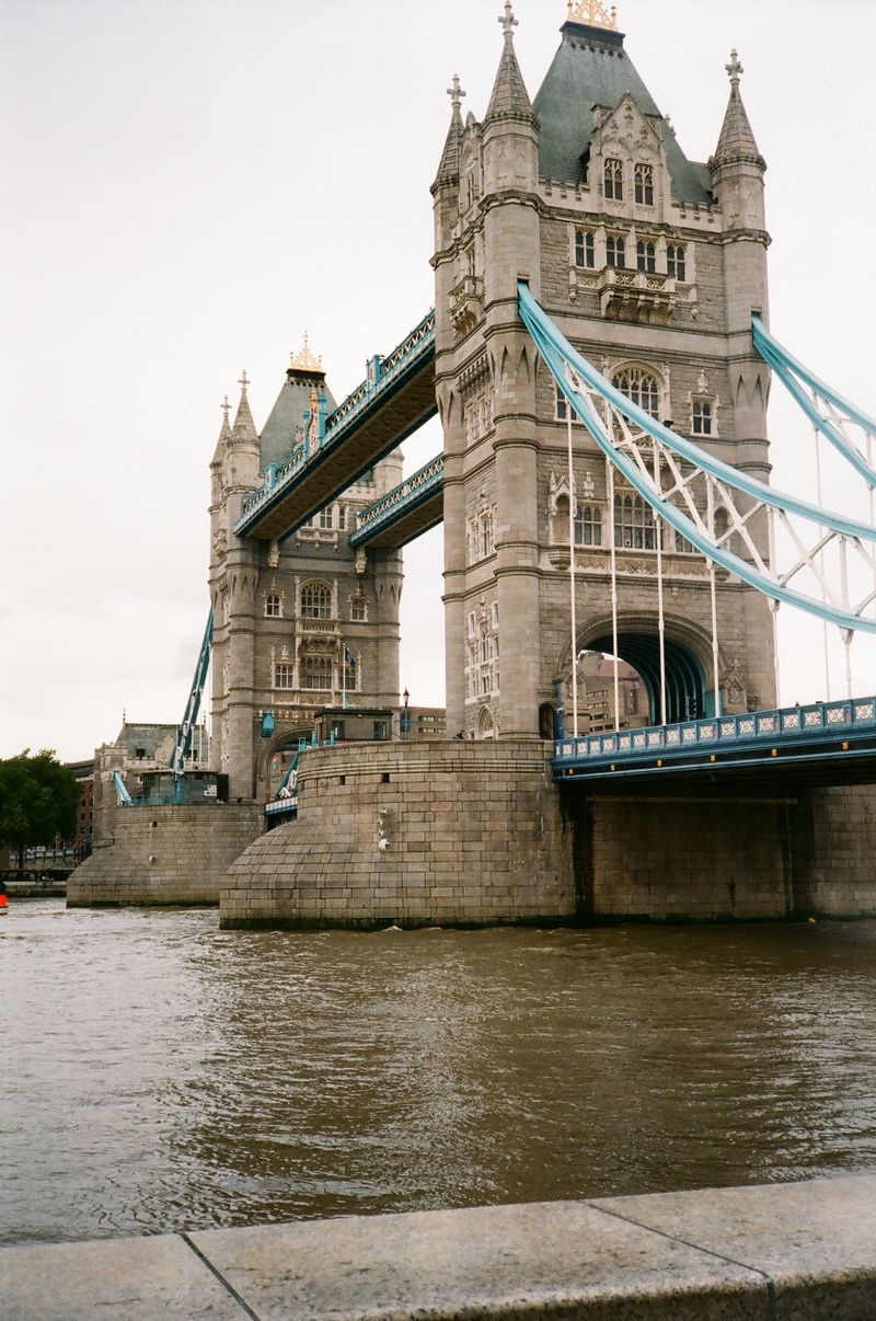 A bridge over a body of water with a castle in the background