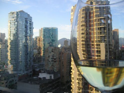 A glass of wine with a city in the background