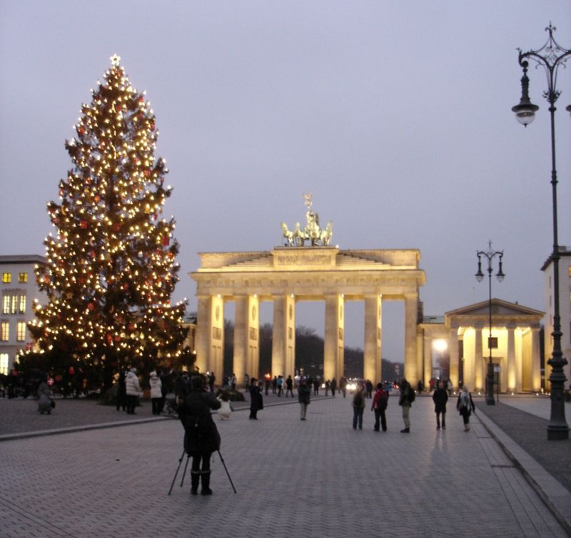 A christmas tree is lit up in front of the berlin gate