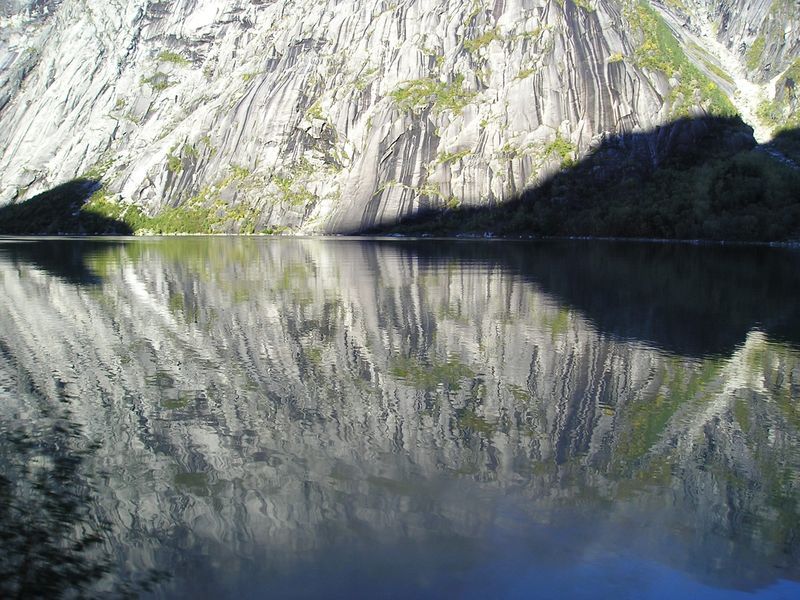 A mountain is reflected in the water of a lake.