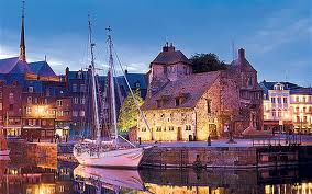 A boat is docked in a harbor with buildings in the background.