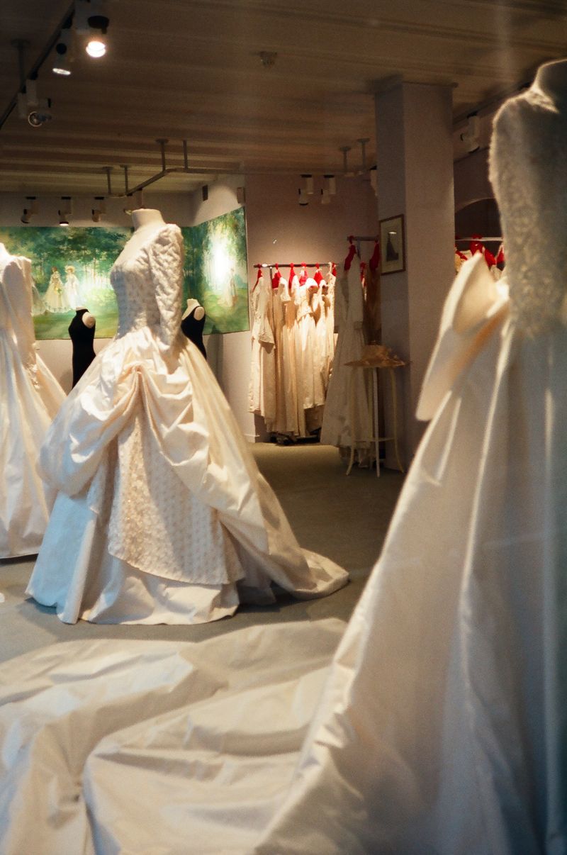 A row of white wedding dresses on mannequins in a store