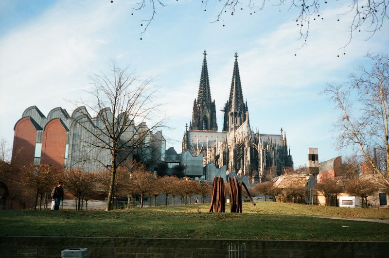 A large cathedral is in the background of a park