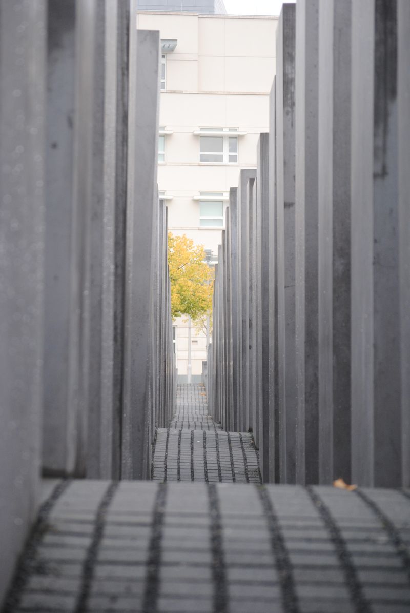 A row of concrete columns leading to a building.