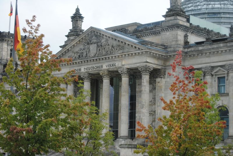 A large building with columns and trees in front of it.