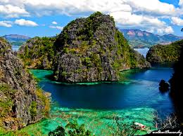 A large body of water surrounded by mountains and trees.