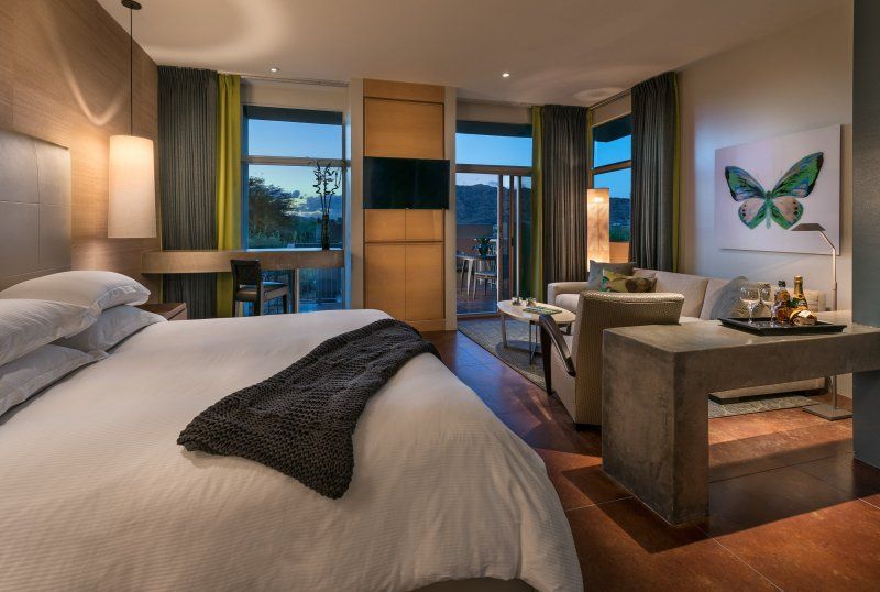 A hotel room with a king size bed and a butterfly painting on the wall.