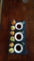 A tray of food with sauces on a wooden table.