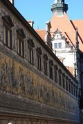 A close up of a wall with a building in the background.