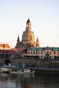 There is a large building in the background and a river in the foreground.