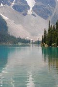 A lake with mountains in the background and trees on the shore.