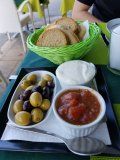 A person is sitting at a table with a tray of food on it.