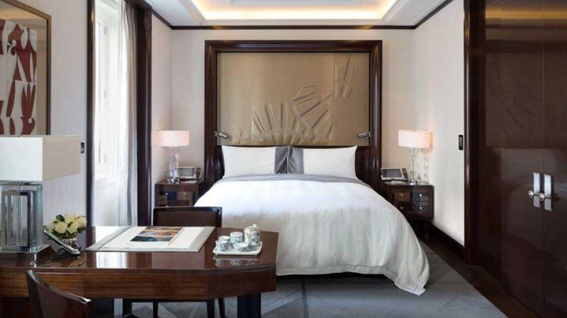 A bedroom with a large bed and a desk