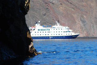 A large cruise ship is floating on top of a body of water.