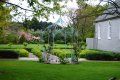A lush green park with a white building in the background.