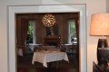 A dining room with a table and chairs and a lamp.