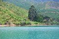 A lake with mountains in the background and trees on the shore.