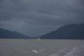 A blurry picture of a lake with mountains in the background on a cloudy day.