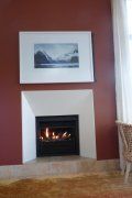 A living room with a fireplace and a picture on the wall above it.