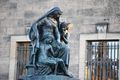 A statue of a man and woman sitting next to each other in front of a building.