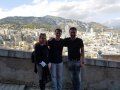 Three people are posing for a picture in front of a city.