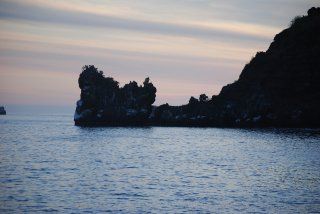 There is a large rock in the middle of the ocean.