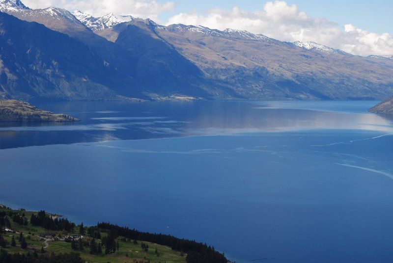 A large body of water surrounded by mountains and trees.