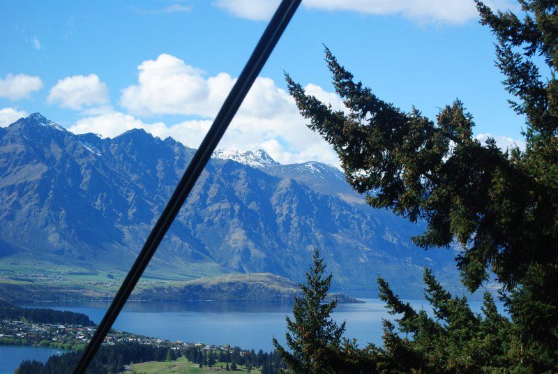 A view of mountains and a lake from a ski lift.
