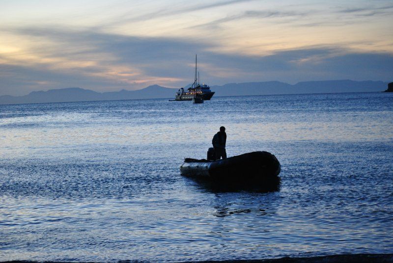 A man sits on a boat in the middle of the ocean