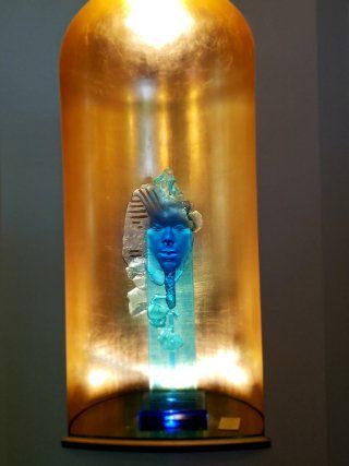 A statue of a man 's head in a glass dome.