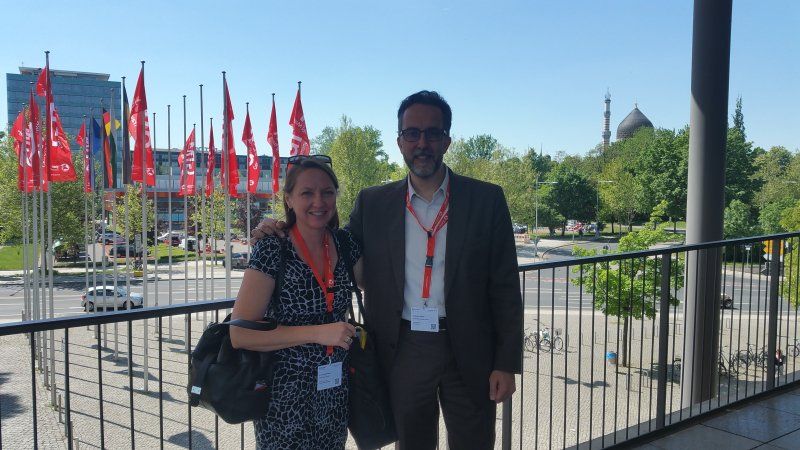 A man and a woman standing next to each other on a balcony