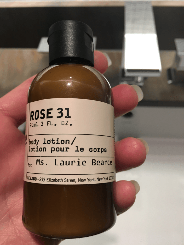 A person is holding a bottle of rose 31 body lotion