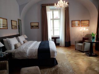 A hotel room with a large bed and a chandelier