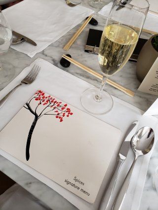 A placemat with a tree on it and a glass of wine