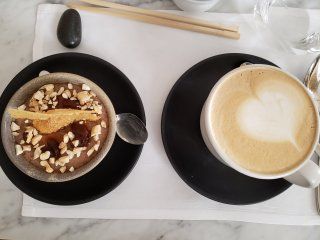Two bowls of food and a cup of coffee on a table