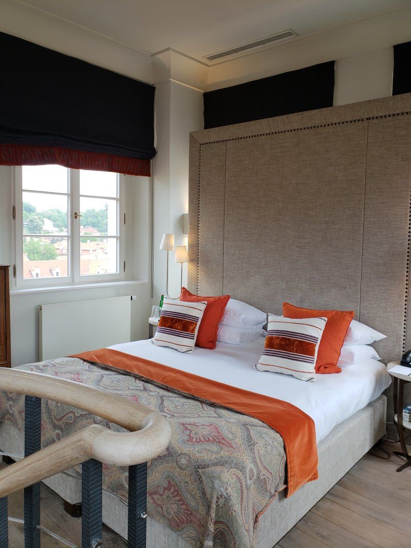 A bedroom with a king size bed and orange pillows
