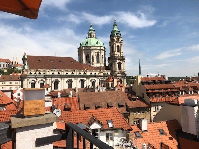 A view of a city from a balcony with a church in the background