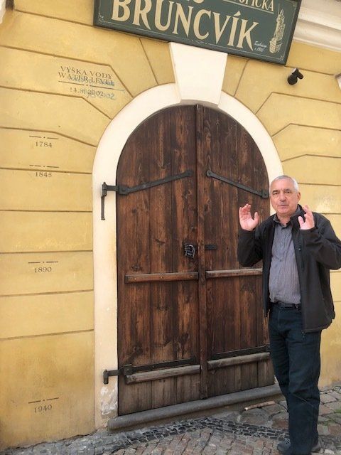 A man stands in front of a building with a sign that says bruncvik